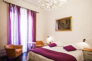 羅馬的住宿－羅馬甜蜜生活酒店，一间卧室配有一张床、两把椅子和一个吊灯