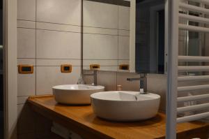 een badkamer met twee witte wastafels op een houten aanrecht bij Locanda Dal Sor Francesco in Vetralla