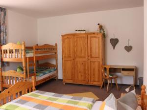 ein Schlafzimmer mit einem Etagenbett und einem Holzschrank in der Unterkunft Gefildehof Göpel in Eisenach