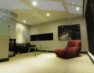 ブルームフォンテーンにあるCity Living Boutique Hotelのリビングルーム(赤い椅子、テーブル付)