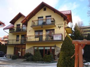 a large yellow building with balconies on it at APARTAMENTY u KOWALA in Szczawnica