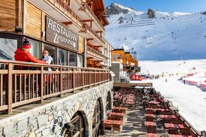 um grupo de pessoas sentadas numa varanda numa estância de esqui em Hôtel Le Levanna by Les Etincelles em Tignes