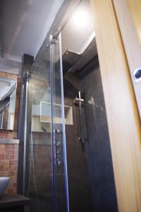 La salle de bains est pourvue d'une douche avec une porte en verre. dans l'établissement Wood Stone and Wine, à Beaune