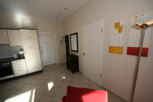 eine Küche mit weißen Schränken und einem roten Stuhl im Zimmer in der Unterkunft Haus Möwe I Whg 02 mit Terrasse in Ostseebad Sellin + 31 Fotos