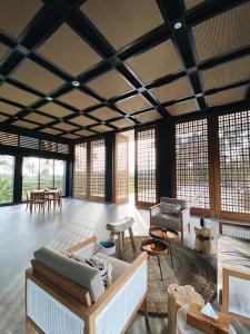 a living room with a lot of furniture and windows at Umah Tirta in Ubud