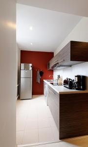 a kitchen with red walls and a refrigerator at Appartement Quai N° 5 in Strasbourg