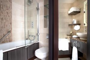 uma casa de banho com uma banheira, um WC e um lavatório. em Jumeirah Lowndes London em Londres