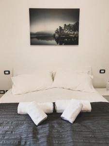 1 cama blanca grande con 3 toallas blancas. en Caput Mundi Anagina IV en Roma