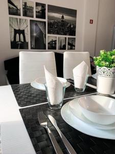 un tavolo bianco e nero con piatti e argenteria di Caput Mundi Anagina IV a Roma