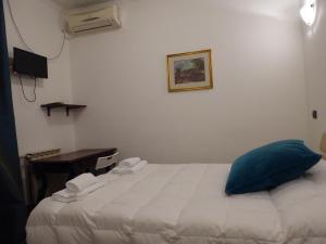 um quarto com uma cama com uma almofada azul e uma secretária em La Dolce Vita Roma em Roma