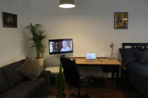 a living room with a desk with a laptop on it at Apartamenty Gołębia 3 in Krakow