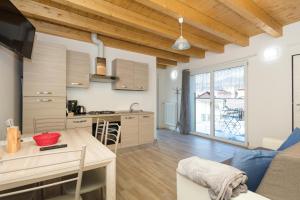a kitchen and living room with a table and a couch at Residenze Lariane in Colico
