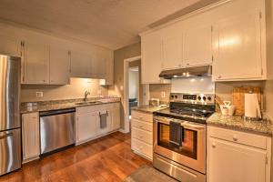 uma cozinha com armários brancos e electrodomésticos de aço inoxidável em Cozy Home with Fenced Yard Less Than 1 Mi Downtown Matthews! em Charlotte