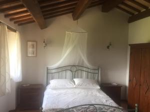 1 dormitorio con 1 cama blanca con dosel en Casa Edera, en Montelparo