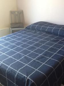 a blue comforter on a bed in a bedroom at Logement avec magnifique vue des montagnes in Digne-les-Bains