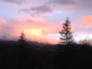 dos árboles en la cima de una colina con una puesta de sol en Logement avec magnifique vue des montagnes, en Digne-les-Bains