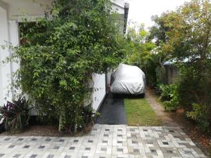 un jardín con una cama en el lateral de una casa en Snowdrop en Negombo