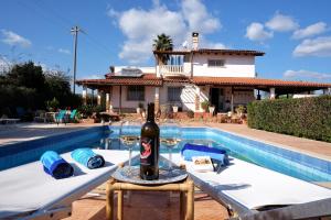 una botella de vino sentada en una mesa junto a la piscina en B&B Il Mandorleto Avola, en Avola