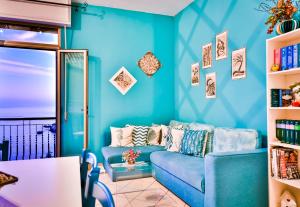 - un salon bleu avec un canapé bleu dans l'établissement Cohen Smart House, à Taormine