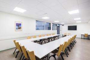 a classroom with tables and chairs and a tv at Centre Jean XXIII in Annecy