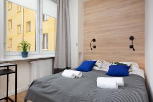 Schlafzimmer mit einem Bett mit blauen und weißen Kissen in der Unterkunft Family City Center Apartments by Renters in Warschau