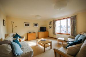 a living room with a couch and a tv at The Flat In The Square in Helensburgh