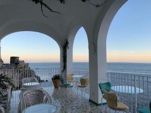 a balcony with chairs and tables and a view of the ocean at Hotel Marina Riviera in Amalfi