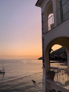 a building on the beach with a boat in the water at Hotel Marina Riviera in Amalfi