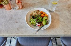 a bowl of salad and a bowl of vegetables on a table at Crowne Plaza Paris République, an IHG Hotel in Paris