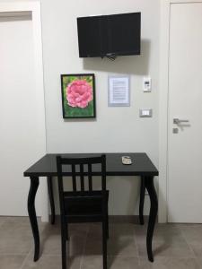 uma mesa preta com uma cadeira e uma televisão na parede em LA DAMA ROOM&BREAKFAST em Russi