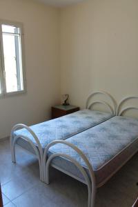 een slaapkamer met een bed met 2 stoelen en een raam bij Villetta Leo in Baia Verde in Il Monte