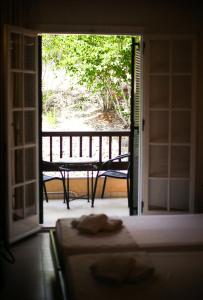 a room with a door open to a patio with a table at Fiori Hotel in Gouvia