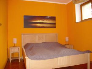 a bedroom with a bed in a yellow wall at Fewoamglubigsee in Wendisch Rietz