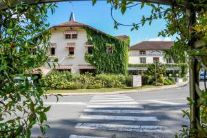 a building covered in ivy on the side of a road at Hotel du Commerce in Amou