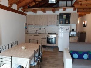 a kitchen with a table and a white refrigerator at Casa Vacanze Roure " BAITA PECIT PARI" in Roure Turin