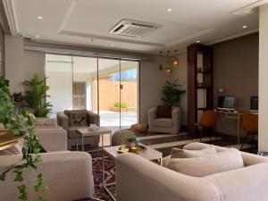 a living room with white couches and a tv at Staytion First - Al Zahra in Jeddah