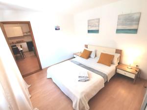 um quarto com uma grande cama branca com almofadas laranja em Apartments Luce em Rovinj
