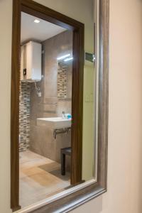 uma casa de banho com um lavatório e um espelho em Lokali Rooms em Il-Gżira