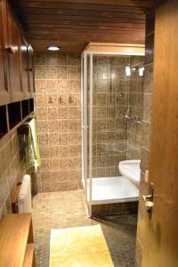 bagno con doccia, vasca e lavandino di Haus Pfauth a Tannheim