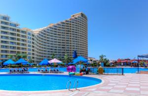 una piscina de hotel con un gran edificio en el fondo en Porto Sokhna Apartment By Amer-Group, en Ain Sokhna