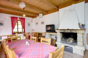 a dining room with a table and a fireplace at Pension U Háčků in Harrachov