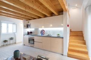 una cucina con pareti bianche e soffitti in legno di Duques Villa Luxury Guesthouse a Lisbona