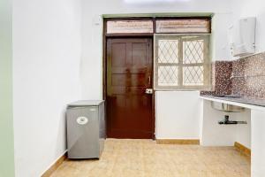 a kitchen with a refrigerator and a brown door at Vivenda Rebelo in Panaji