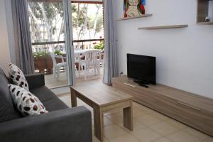 Televisyen dan/atau pusat hiburan di AT125 Els Pins, comunidad con piscina en 1ra línea de la playa