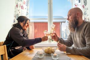 Ein Mann und eine Frau sitzen mit Getränken am Tisch in der Unterkunft Malungs Camping in Malung