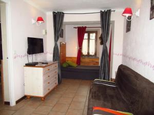 een woonkamer met een bank en een tv en een slaapkamer bij Gîtes la Mexicaine in Jausiers