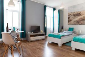 a bedroom with two beds and a table and a television at Jonas Apartments - Great Location near Bratislava City Center in Bratislava