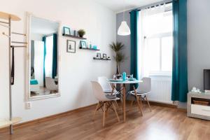 a dining room with a table and chairs and a mirror at Jonas Apartments - Great Location near Bratislava City Center in Bratislava