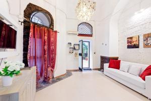 een woonkamer met een witte bank en een open haard bij Charming Sicilian Loft in Catania