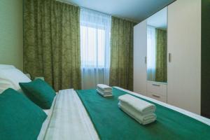 a bedroom with a bed with towels on it at Five Stars on the Waterfront in Nizhnevartovsk